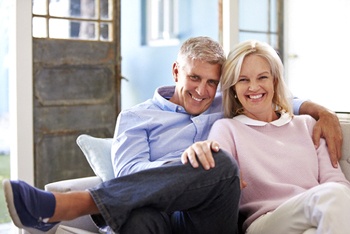 happy older couple sitting on their couch