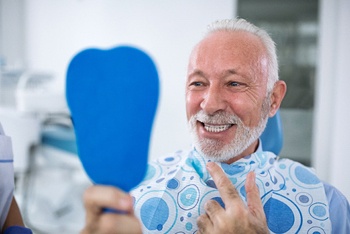 Man checking dental implants in Temple, TX using handheld mirror