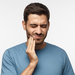 Bearded man in blue shirt with oral pain
