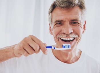 senior man brushing his teeth  
