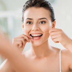 woman flossing her teeth