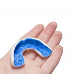 person holding blue mouthguard in their hand