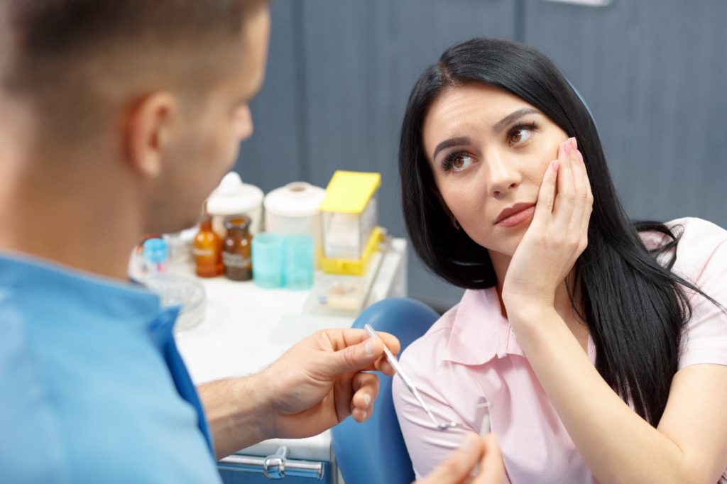 Woman visiting her dentist after experiencing a knocked-out tooth.